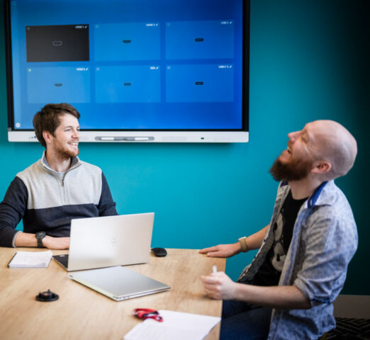 Two men sat at a table discussing a data project