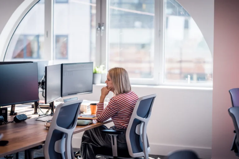                     Woman sitting at a desk in an office.                